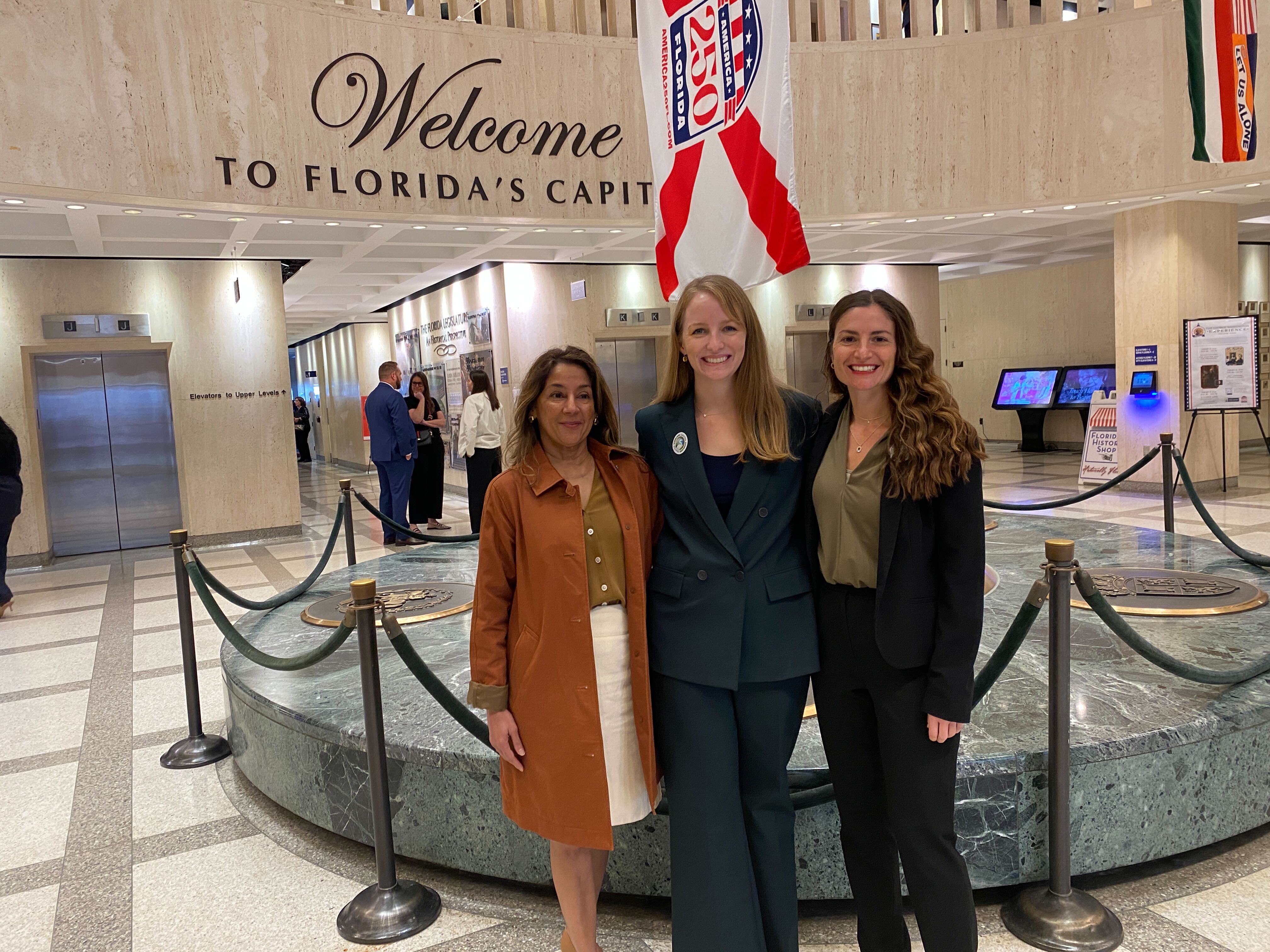 three people smiling at the camera